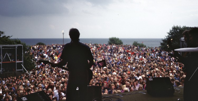 Bjørn Afzelius foran et folkehav på scenen. (Foto: Storytelling Media)