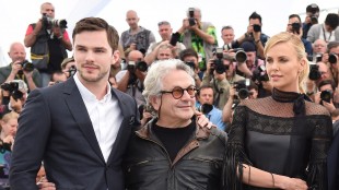 Skuespillerne Nicholas Hoult og Charlize Theron med regissør George Miller mellom seg i Cannes (AFP PHOTO / ANNE-CHRISTINE POUJOULAT)-