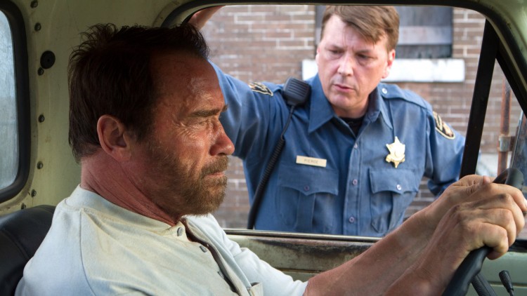 Wade (Arnold Schwarzenegger) blir spurt om datterens tilstand av politimannen Ray (Douglas M. Griffin) i Maggie (Foto: SF Norge AS).