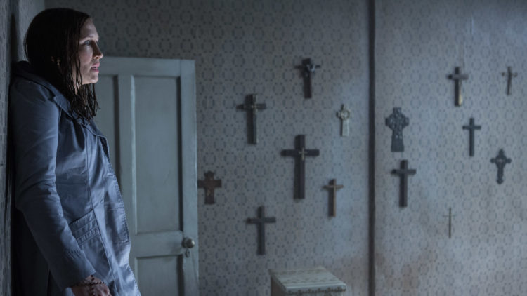 Lorraine Warren (Vera Farmiga) i et rom med kristelig veggpryd i The Conjuring 2. (Foto: SF Norge AS).