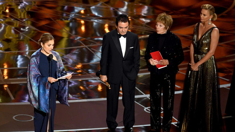 Anousheh Ansari og Firouz Naderi tok imot Oscar-statuetten på vegne av Asghar Farhadi. Prisen ble delt ut av Shirley MacLaine og Charlize Theron. Foto: AFP/NTB Scanpix 