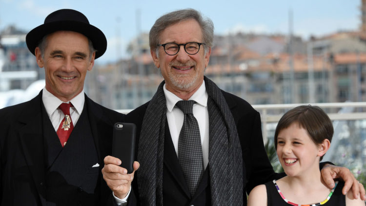 Steven Spielberg filmer (vertikalt!) med mobilen sin, med skuespillerne Mark Rylance og Ruby Barnhill ved sin side i Cannes (Foto: AFP PHOTO / ANNE-CHRISTINE POUJOULAT).