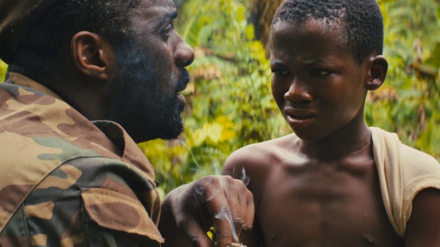 Kommandanten (Idris Elba) tar Agu (Abraham Attah) under sin vinge i Beasts Of No Nation (Foto: Netflix).