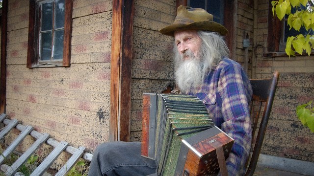 MUSIKALSK COWBOY: Den 94 år gamle ungkaren John Hoiland  driver fremdeles sin ranch i Montana etter gammel manual. Men til tross for travle dager er det tid til en trudelutt på trammen. FOTO: FIMfilm AS