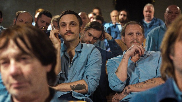 FENGSLET: Hans (Franz Rogowski) og Viktor (Georg Friedrich) ser på TV med de andre innsatte i «Den store friheten». Foto: AS Fidalgo