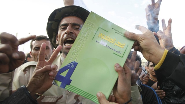 Muammars "lille grønne bok" brennes av demonstranter. (Foto: REUTERS/Asmaa Waguih)