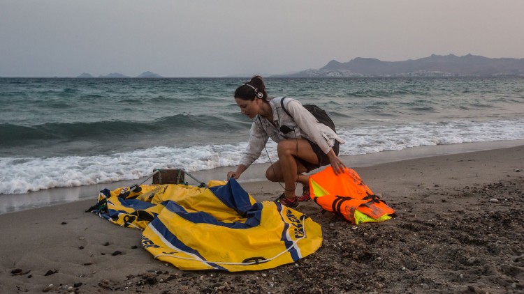 Silje Ese sjekker en ødelagt gummibåt på stranda i Kos. (Foto: Foto: Marius Arnesen, NRK).