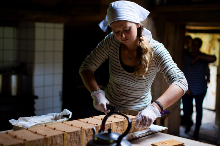 Camilla Vanessa Askeland (23) skjærer opp den første brunosten hun har laget selv. Den har fått navnet Berta, etter bestemoren hennes. Foto: Wanda Nathalie Nordstrøm