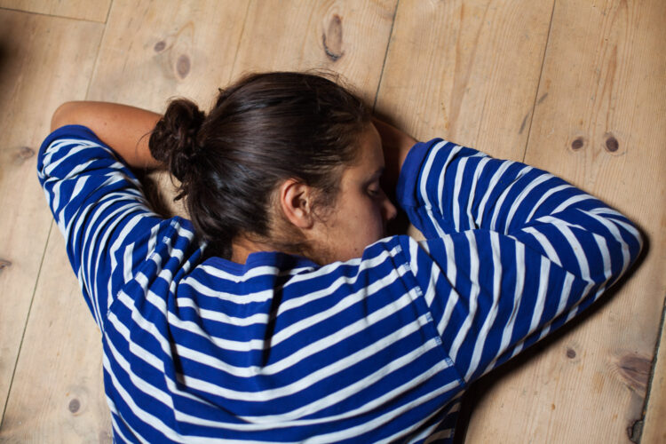 Det er lange dager på setra, Aisha Marie Heim (23) tar et minutts hvil på gulvet. Foto: Wanda Nathalie Nordstrøm