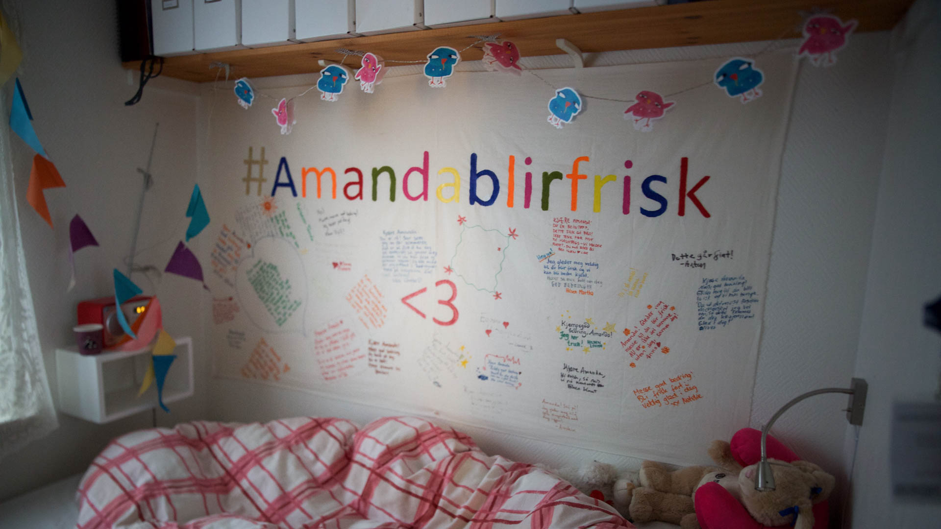 En stor hilsen fra gjengen på Natur og Ungdom-kontoret henger ovenfor sengen til Amanda. (Foto: Anne Dorte Lunås, NRK)
