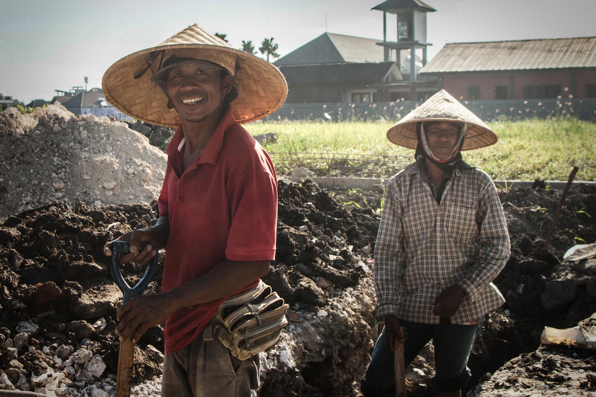 Smilende balinesere ved veikanten. De jobber med store hatter for å beskytte seg mot den sterke solen. (Foto: Andrea A. Thiis-Evensen)