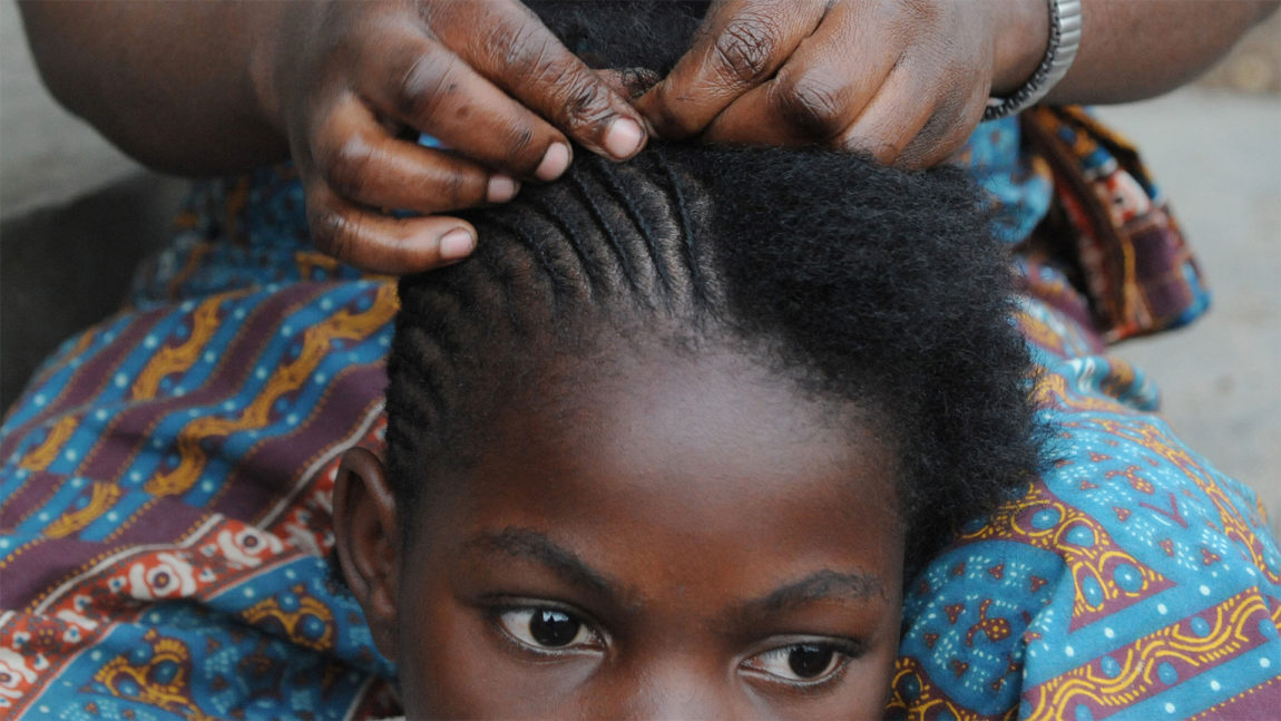 Jente blir flettet på tradisjonelt afrikansk vis. Kjent som frisyren corn rows. (Foto: Roberto Schmidt, Scanpix/AFP)