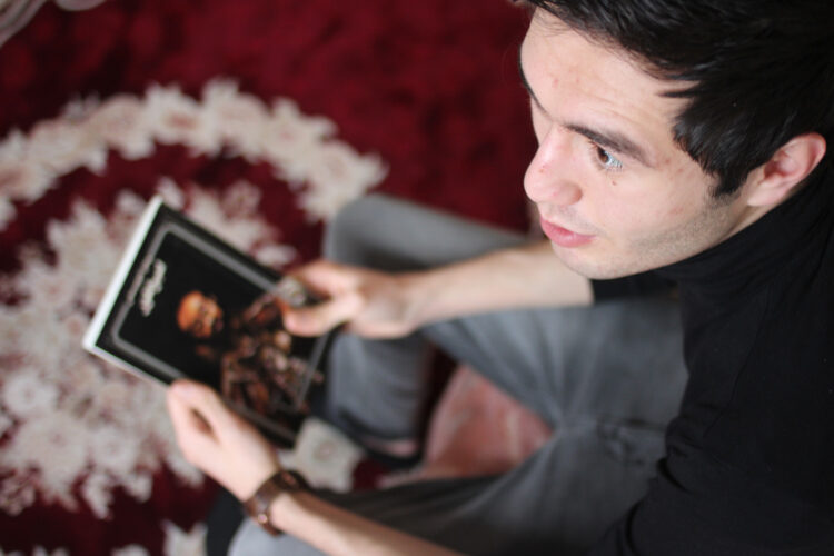 Majid elsker realfag og å lese. Her sitter han med en bok av den polske journalisten Ryszard Kapuściński. Foto: Frid K. Hansen