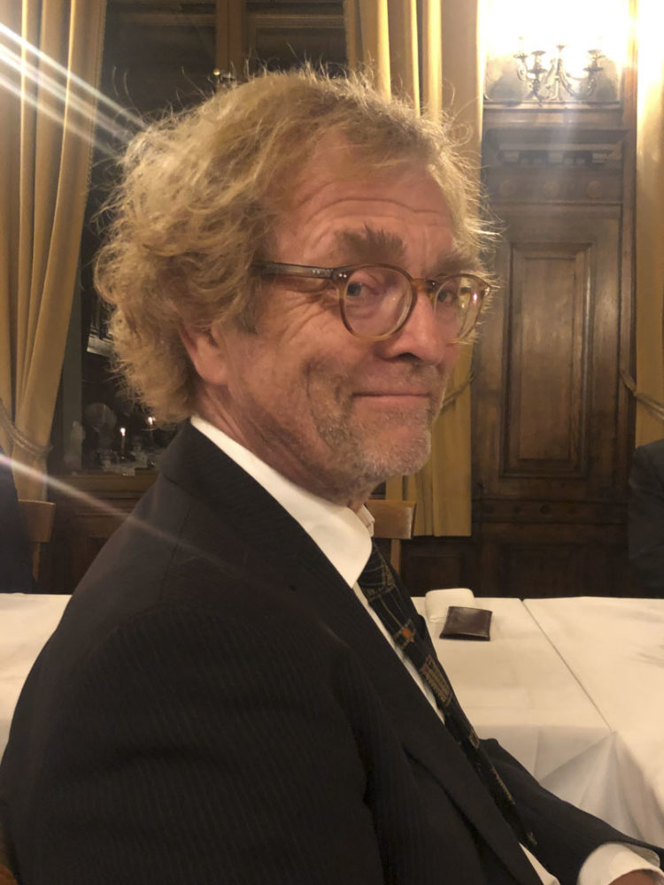 Bilde av forsker Svein Mossige som har på en sort dress mens han stilt litt på sida. Han har på briller og ser inn i kamera.