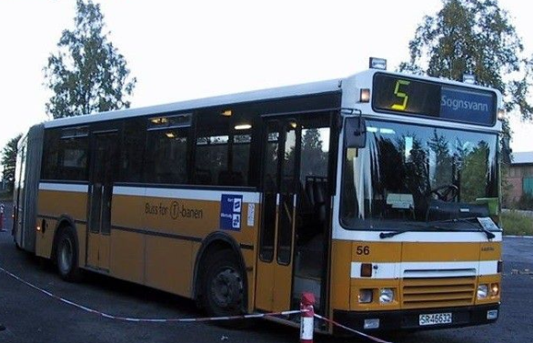 Gul buss med kvite striper, tar seg av t-baneline 5 rundt Songsvann i Oslo. 