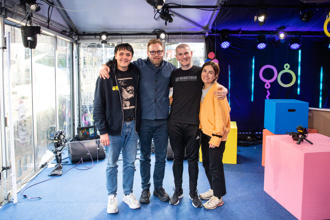 Martin, Tore, Henrik og Adelina poserer smilende sammen i studio