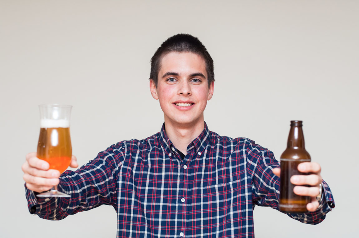 17-år gamle Marius smiler fra øret til øret. Han holder en øl i hver hånd, og har på seg en rutete skjorte. 