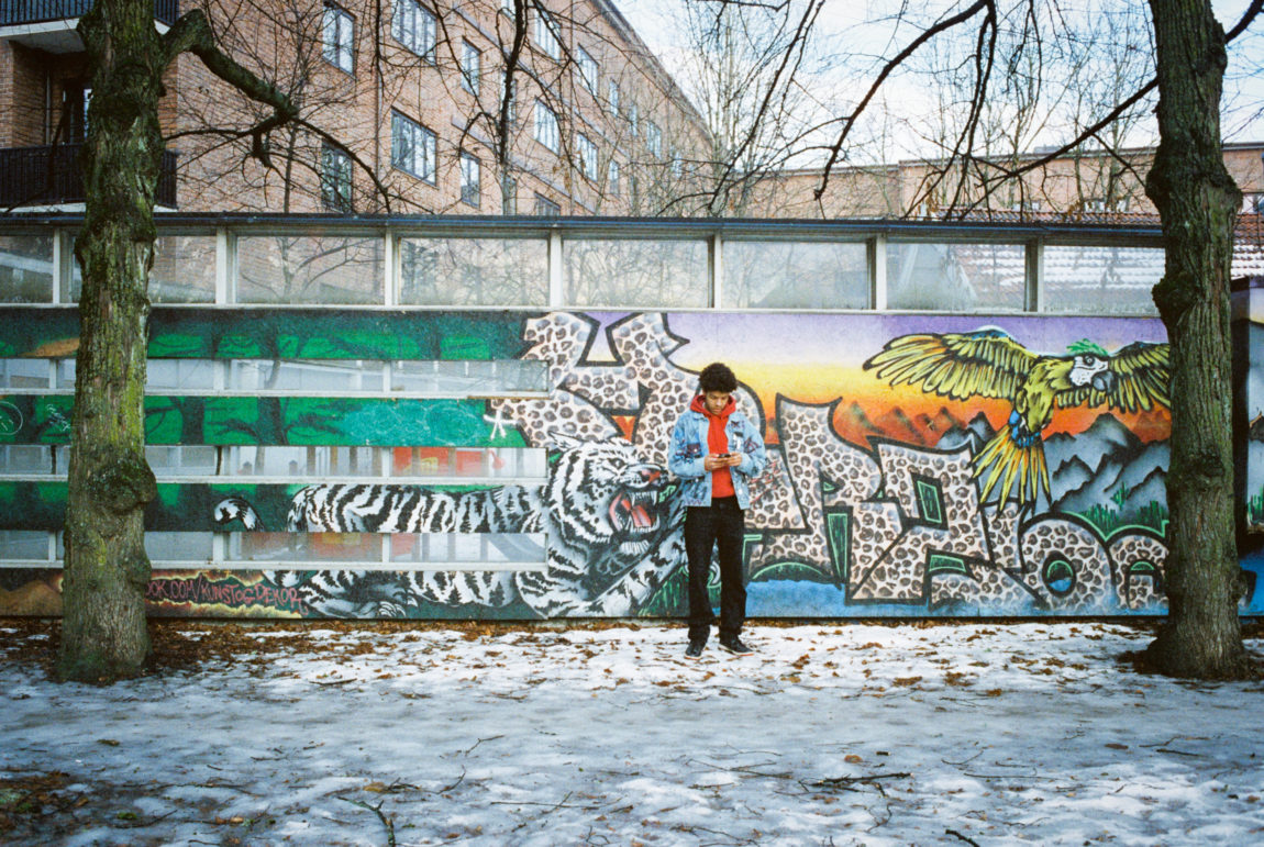 Makosir står fremfor en graffitivegg på Sagene i Oslo, mens bakken under han er dekket med delvis smeltet snø.