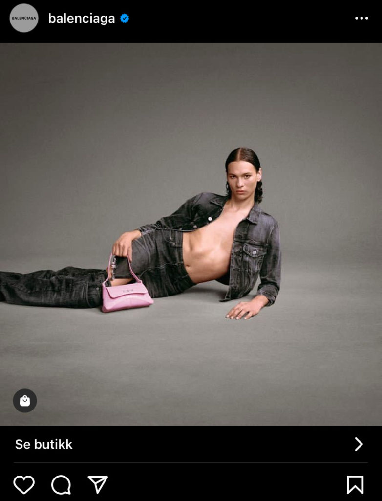 Skjermbildet fra Instagram er lagt ut av konten til Balenciaga. Inti ligger sidelengs på det grå gulvet og ser inn i kamera. Han har på seg matchende olaklær i grått med en lyserosa vekse til. 