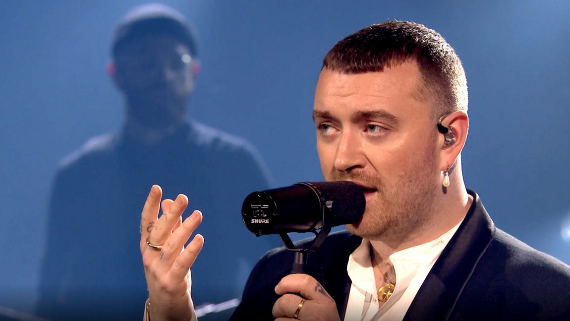 Sam Smith synger inn i mikrofonen og ser seriøs ut.