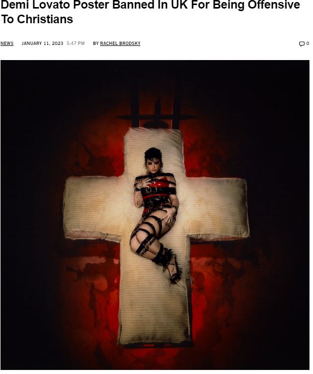 Bildet er en faksimile. Man ser musikknettstedet Stereogum legge ut overskriften "Demi Lovato Poster Banned in UK for Being Offensive To Christians" sammen med et bilde av plakaten. På plakaten er Demi Lovato iført en latex-drakt som viser mye hud, og hun ligger oppå en gigantisk madrass formet som et kors.