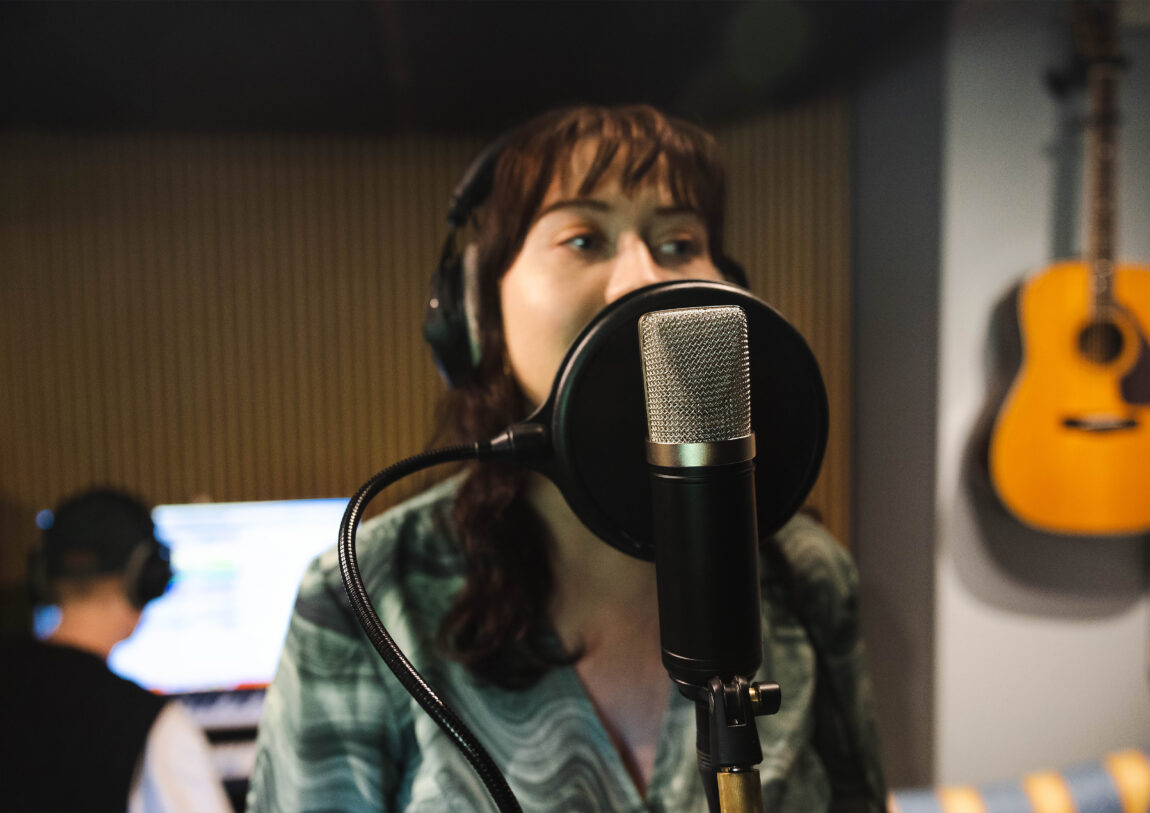 Milja Jørgensen synger inn i en studiomikrofon.