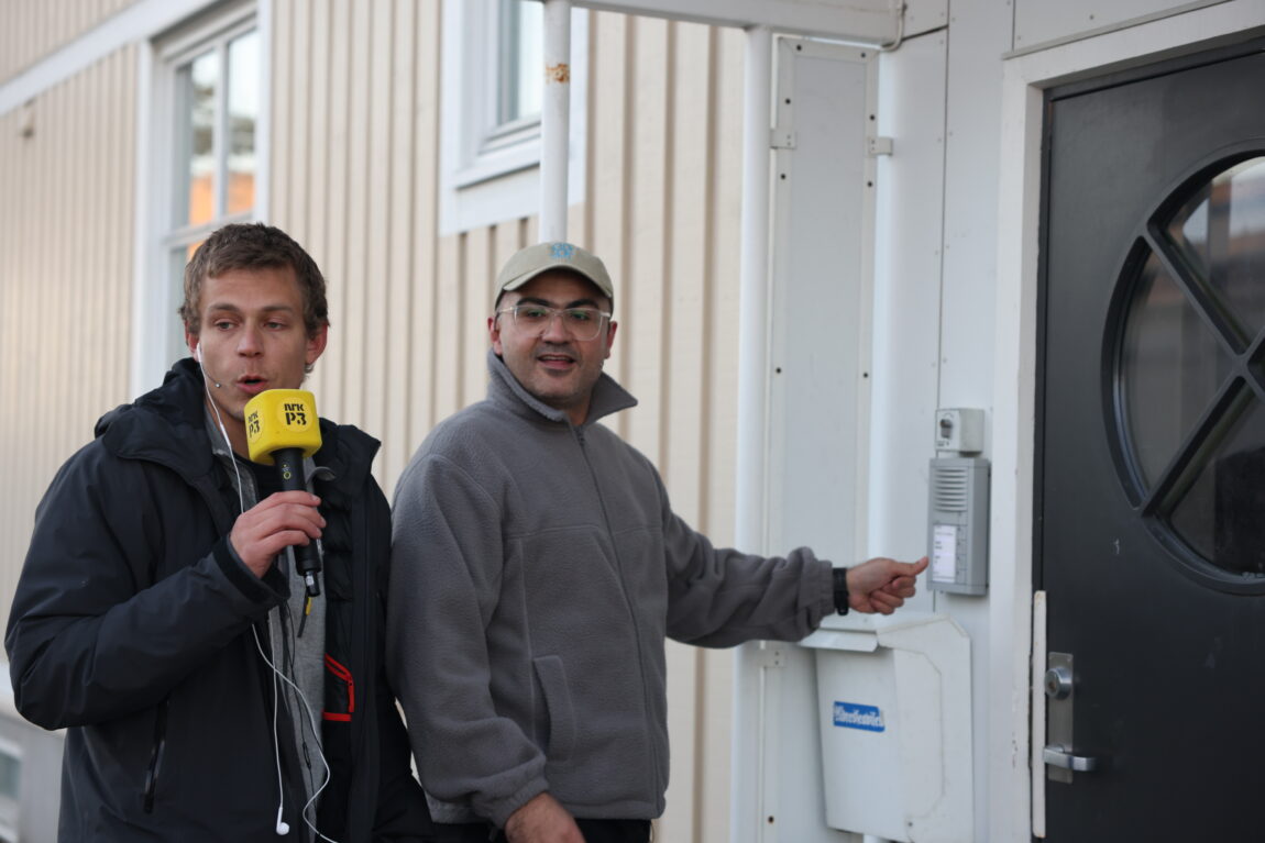 Steinar og Galvan står utenfor et hus. Galvan trykker på ringeklokka.