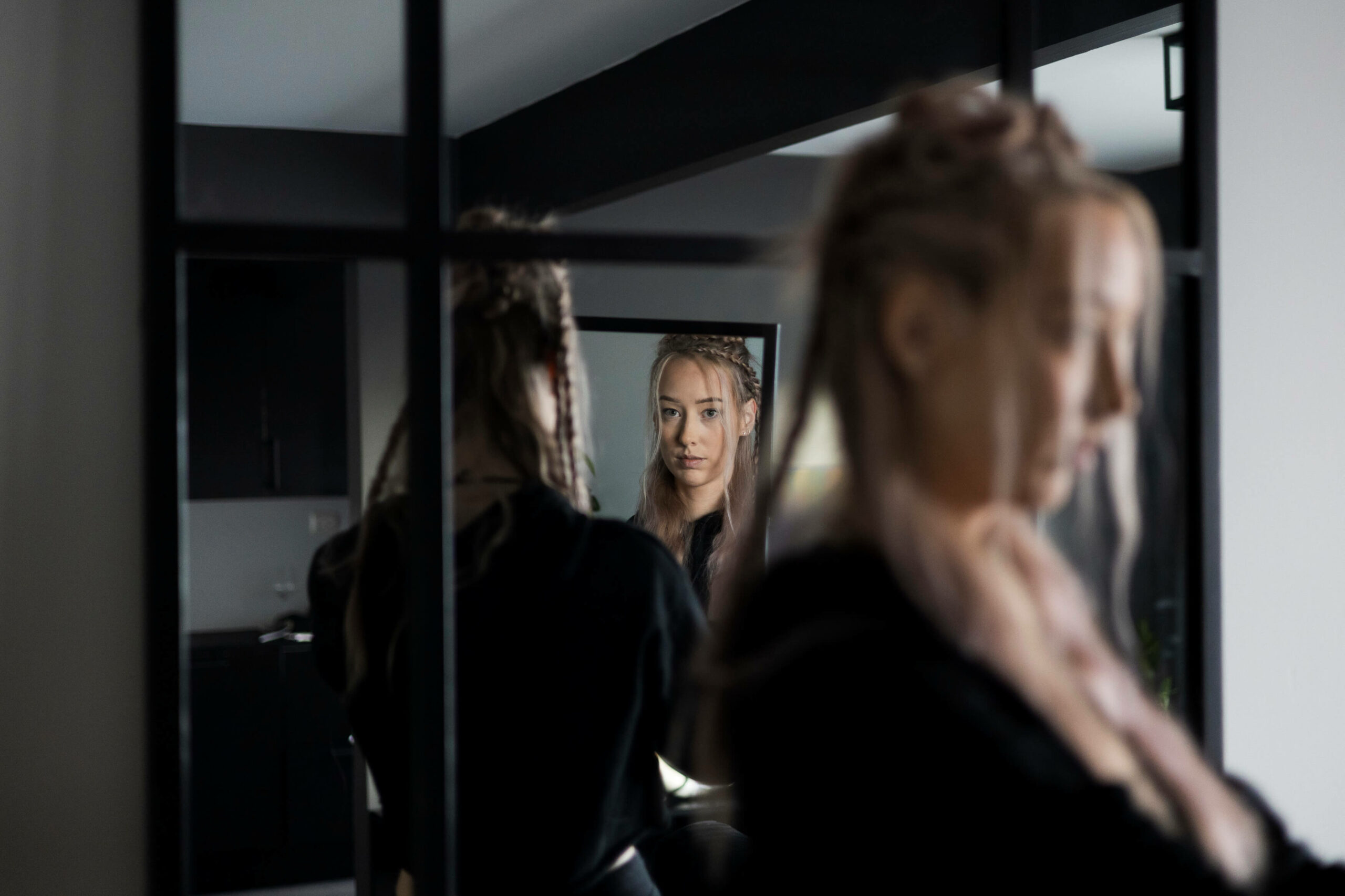 Catharina har teke med seg spegelen bort til ein større spegel for å kunne sjå korleis hårfirsyren ser ut bakfrå. Dette skapar fleire forskjellige refleksjonar av ho. Mist i biletet ser Catharina i spegelen og rett i kameraet.
