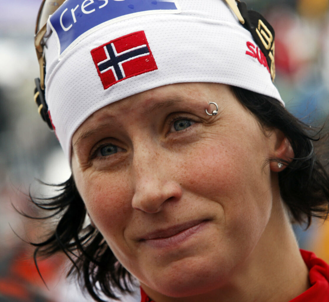 Marit Bjørgen er sliten og svett og har på seg en bhvit lue og en piercing i øyenbrynet.