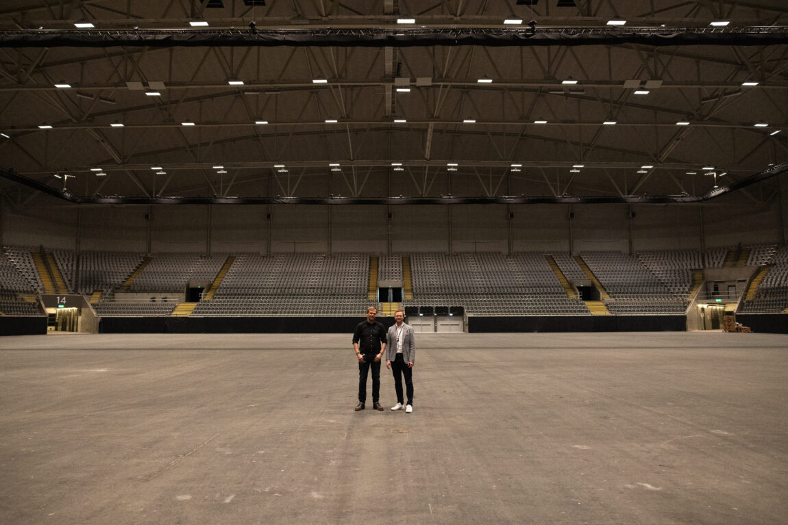 Marius og Kjetil står midt i Telenor Arena. Bak dem er det helt tomt, og i det fjerne ser vi tribunen.