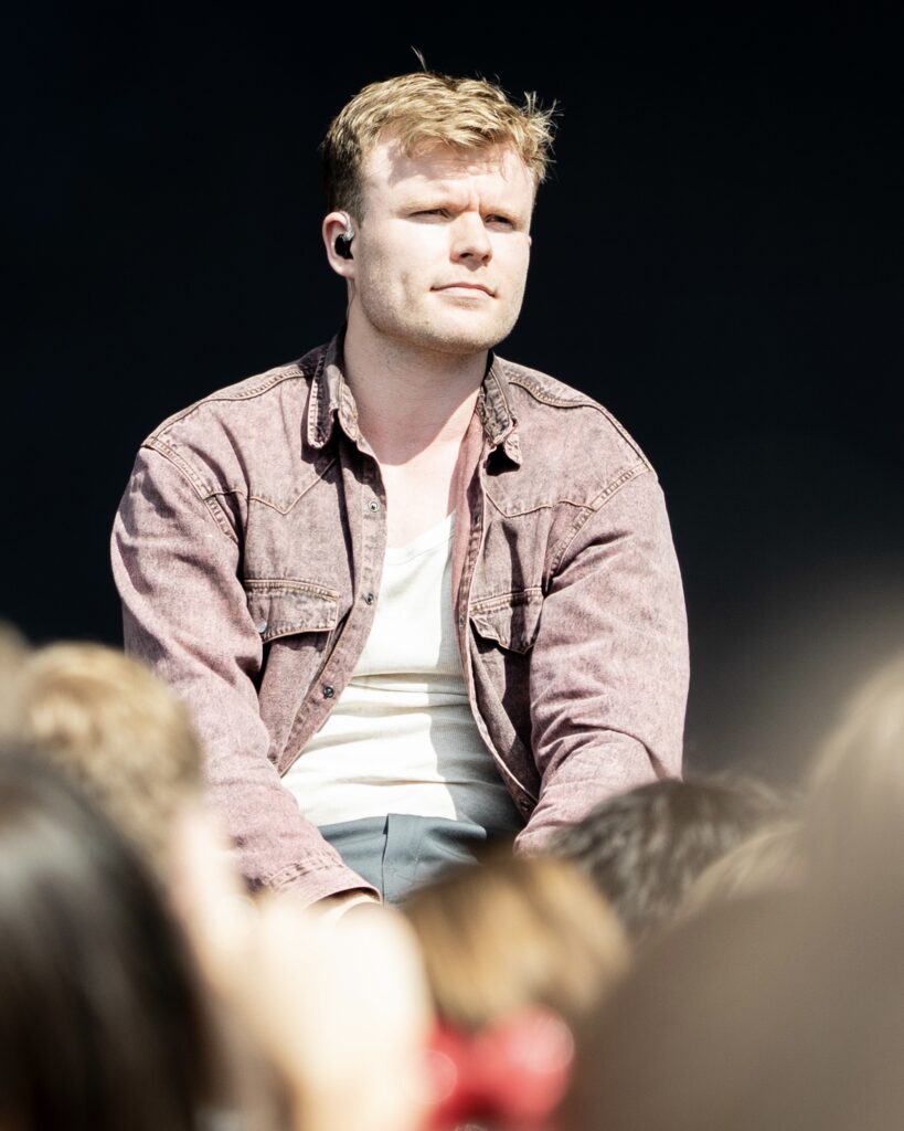 Håvard sitter på scenekanten mens han fremfører låten «Vestlandsflørt».