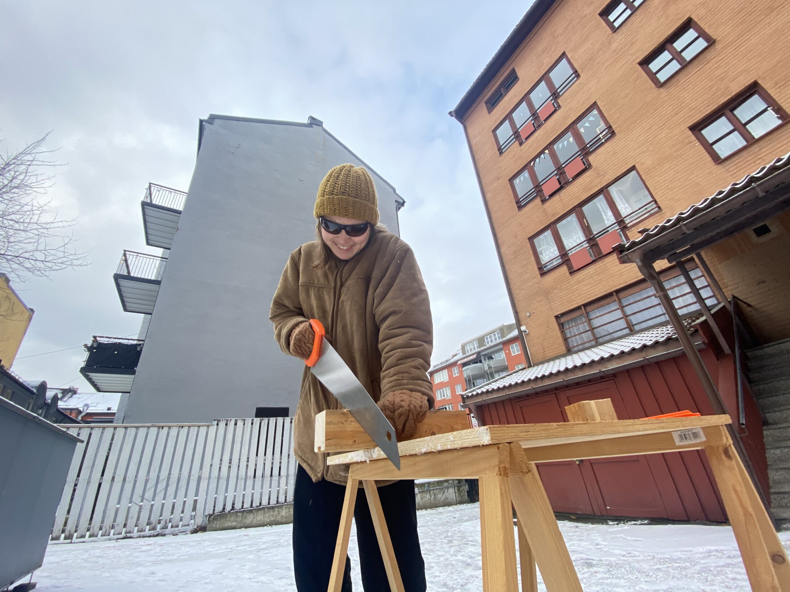 Et av medlemmene i Uironsik Distanse sager i hagen om vinteren