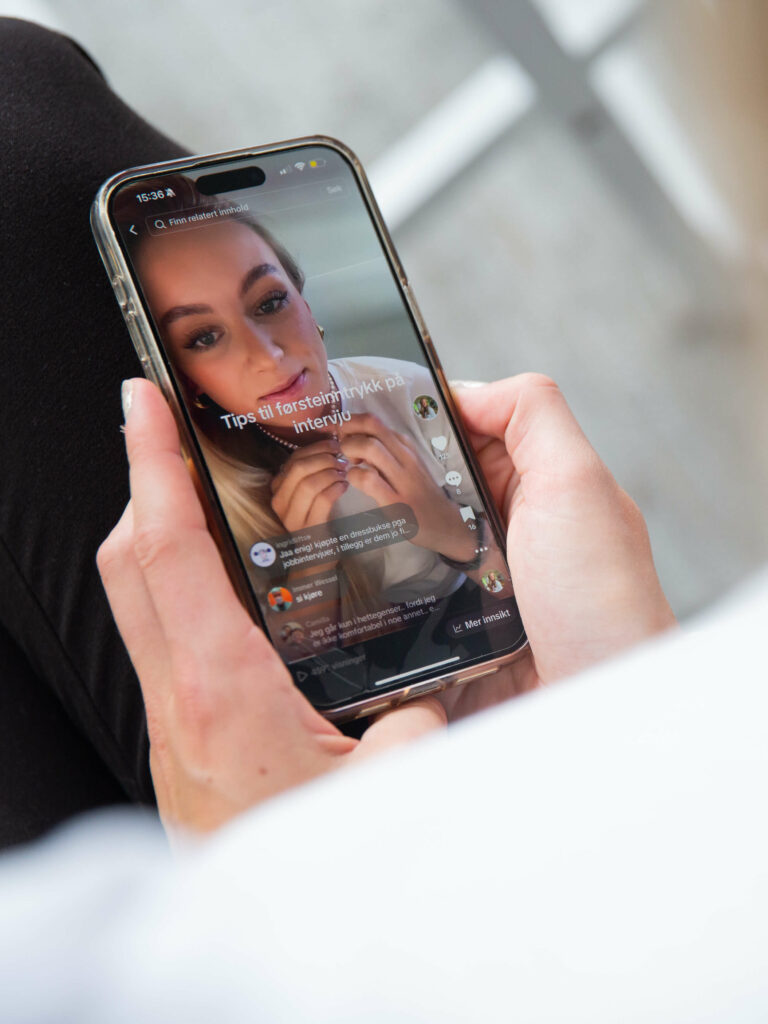 Biletet viser ein iPhone. På mobilen visast TikTok-videoen som Maria Kleven spelte inn. På skjermen står det "Tips til førsteinntrykk på jobbintervju".