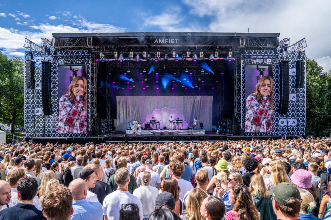 Oversiktbilde av Øya-festivalens største scene. Vi ser et hav av publikummere. De står vendt mot en stor scene, med en skjerm på hver side. Et band på seks stykker står på scenen. 