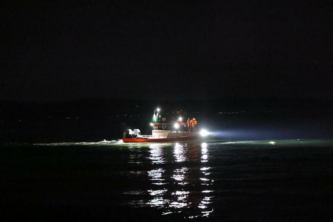 Redningsskøyta er ute på Trondheimsfjorden. Det er mørrkt ute og lys fra båten lyser ut på sjøen.