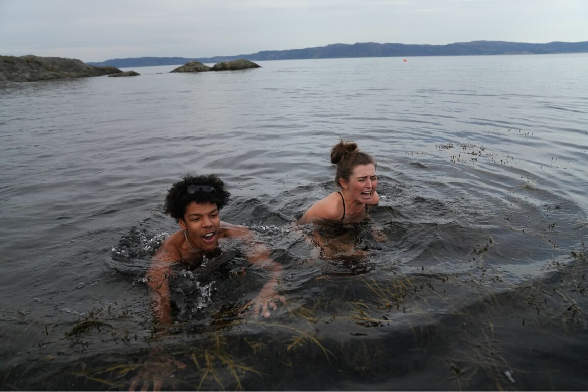 Makosir og Annika bader i Korsvika i Trondheim. Rundt dem er det tang. De ser begge ut som de har det litt vondt.