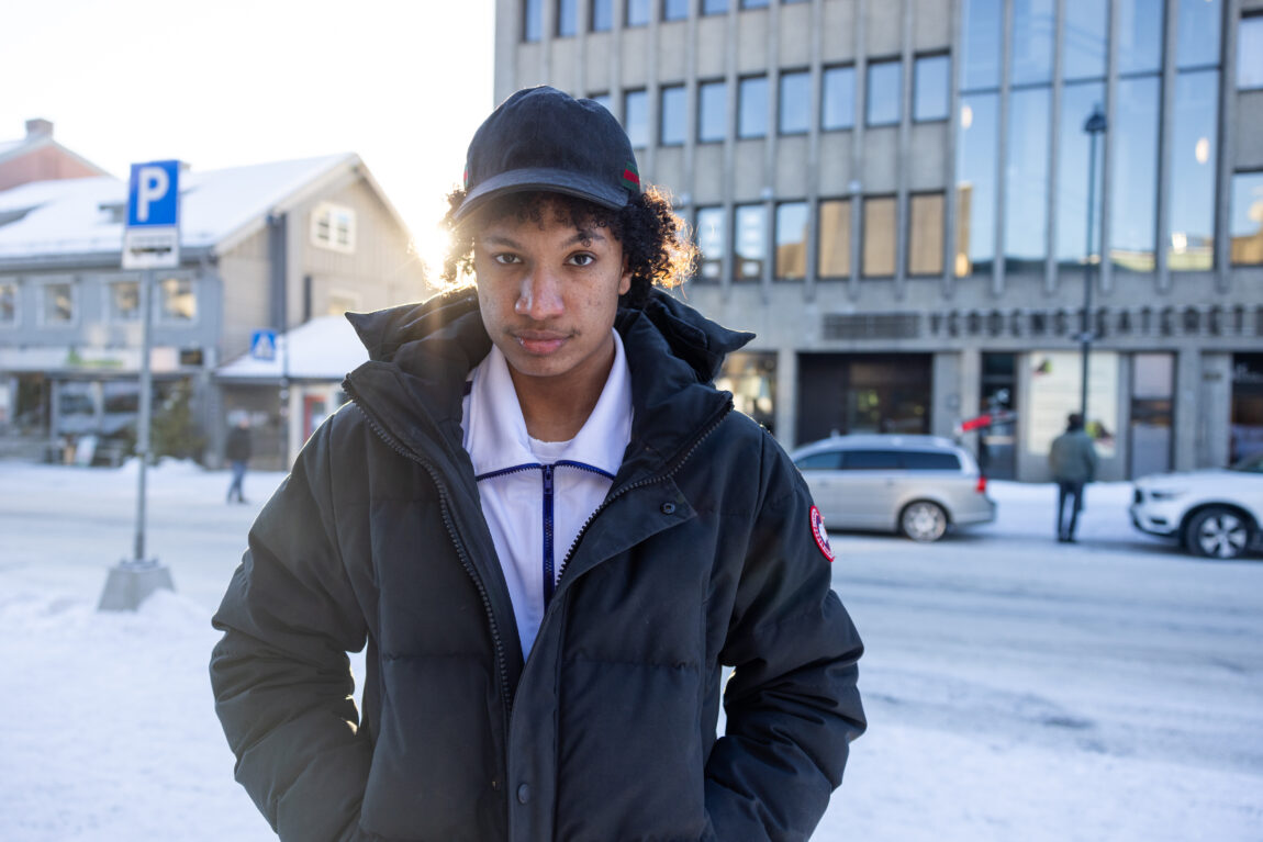 Daniel Obede står foran Limpi. Han har på seg en hvit tracksuite over en svart vinterjakke og en svart caps.