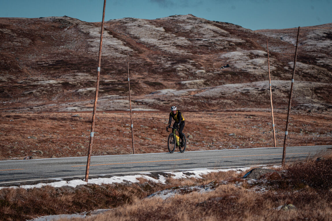 Sindre blir liten på sykkelen med de store viddene i bakgrunnen.