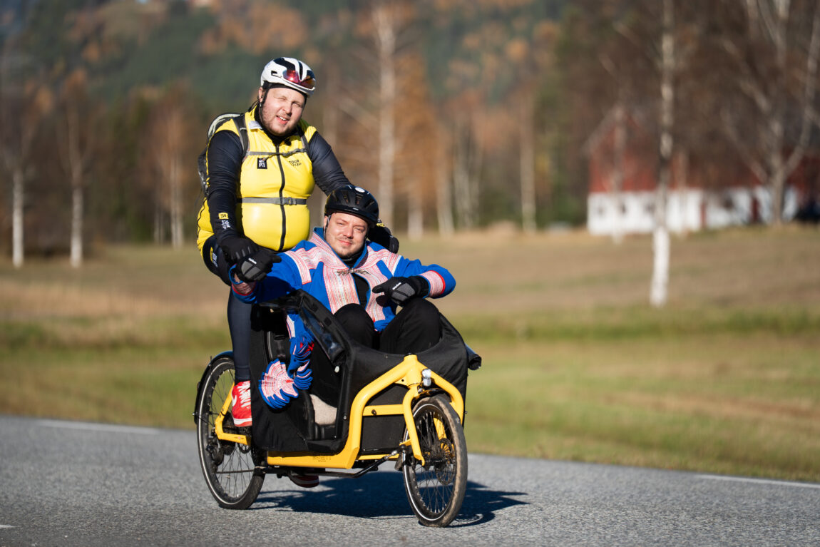 Jonas sykler med Fred i en sykkelkurv på en gul sykkel.