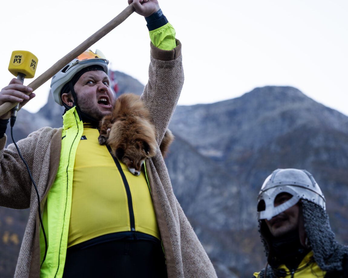 Jonas ser gærn ut inn i kamera med åpen munn. Han har en rev rundt halsen.