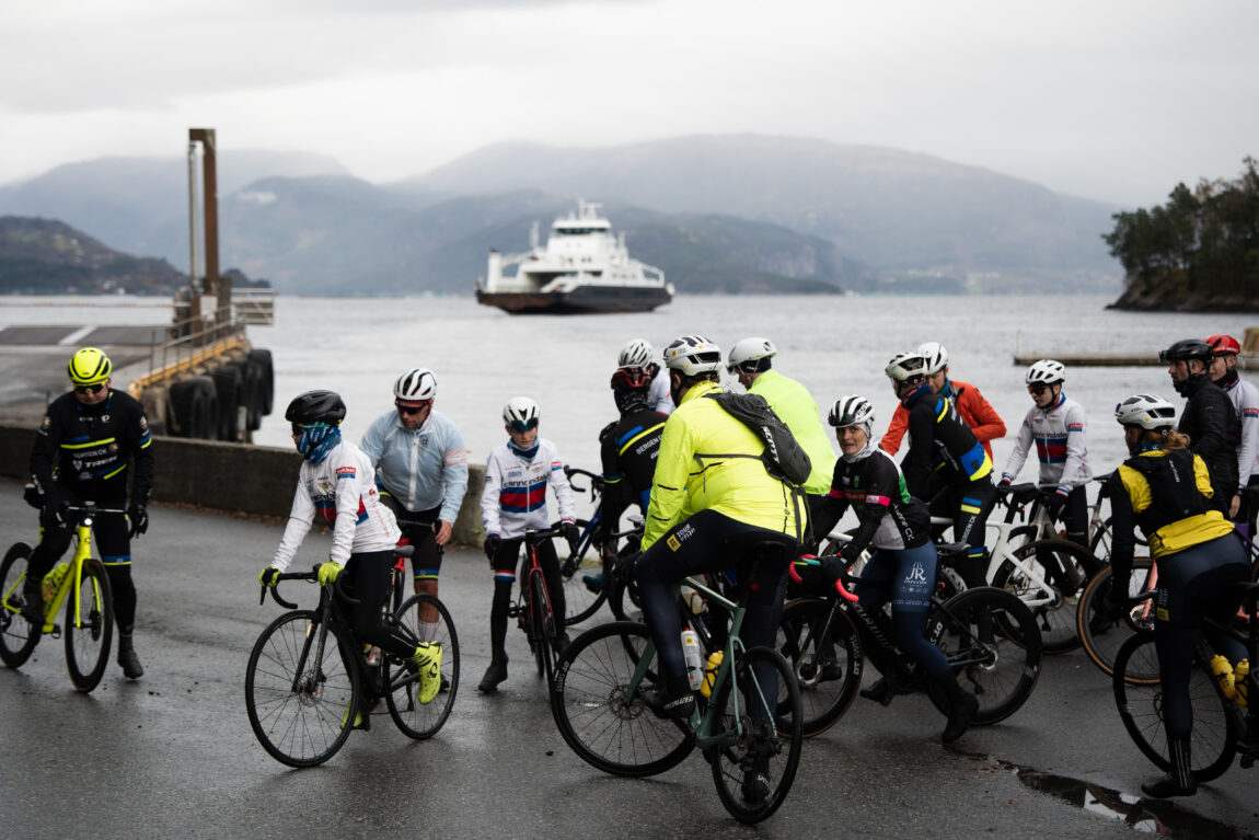 Jonas sin rygg skimtes blant flere syklister på fergekaia.