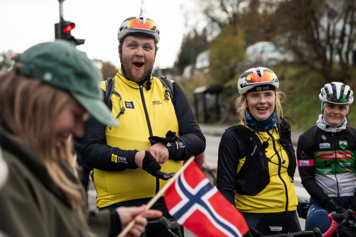 Jonas kikker gira med åpen munn inn i kamera idet de får kake langs veien, Anna ser også fornøyd ut.