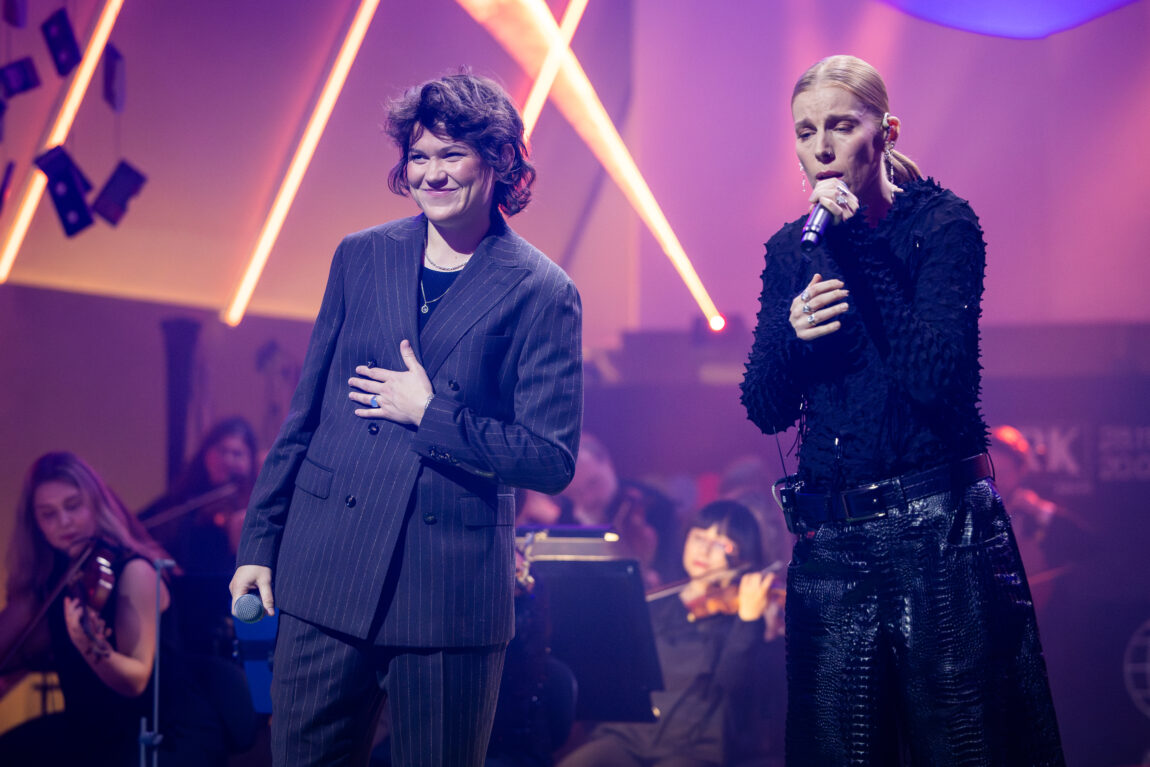 Gabrielle og Fay står på scenen og synger.